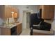 Galley kitchen with wood cabinets, black appliances, and tile floor at 1695 Lee Rd # A209, Winter Park, FL 32789