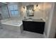 Bathroom featuring a soaking tub with marble surround, tiled shower, and vanity with marble countertop at 205 Hazard St, Orlando, FL 32804