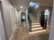 Bright hallway with wooden floors leading to a staircase, showcasing the home's layout at 205 Hazard St, Orlando, FL 32804