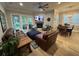 Open-concept living room with leather furniture, fireplace, ceiling fan and light hardwood floors at 205 Hazard St, Orlando, FL 32804
