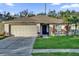 Cute one-story house with a well-maintained lawn and attached garage at 211 Lynn St, Oviedo, FL 32765