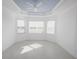 Spacious bedroom with light-colored walls, tile flooring, and a tray ceiling at 240 Blue Starfish Pl, Daytona Beach, FL 32124