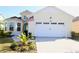 Inviting yellow home with a two-car garage and a neatly paved driveway at 240 Blue Starfish Pl, Daytona Beach, FL 32124