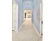 Long hallway with blue walls, white trim, and tile flooring leading to the living area at 240 Blue Starfish Pl, Daytona Beach, FL 32124