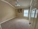 A comfy bedroom featuring a ceiling fan, neutral carpet, and a bright window at 2544 Ashville Ave, The Villages, FL 32162