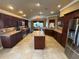 Open-concept kitchen with stainless steel appliances, island, and ample counter space at 2544 Ashville Ave, The Villages, FL 32162