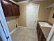 Functional laundry room with cabinetry, sink, and tile flooring at 2544 Ashville Ave, The Villages, FL 32162