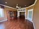 Spacious living room featuring hardwood floors, a ceiling fan, and a built-in wooden entertainment center at 2544 Ashville Ave, The Villages, FL 32162