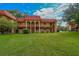 Two-story building with red tile roofs, balconies, and a lush green lawn at 2858 N Powers Dr # 123, Orlando, FL 32818