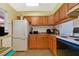 Kitchen with wood cabinets, white appliances, and ample counter space at 2858 N Powers Dr # 123, Orlando, FL 32818
