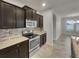 Kitchen features dark brown cabinets and granite countertops at 2943 Top Water Way, Kissimmee, FL 34746