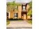 Tan two-story townhome with dark brown shutters and a paved driveway at 3428 Calabria Ave, Davenport, FL 33897