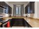 Modern kitchen boasts dark cabinetry, granite countertops, and stainless steel appliances at 3428 Calabria Ave, Davenport, FL 33897