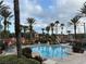 Beautiful resort-style pool surrounded by palm trees and lounge chairs for relaxation at 3428 Calabria Ave, Davenport, FL 33897