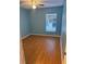 Light blue bedroom with wood-look flooring and a window overlooking the backyard at 371 Lexingdale Dr, Orlando, FL 32828