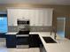 Updated kitchen with white and dark cabinets, quartz countertops, and stainless steel appliances at 371 Lexingdale Dr, Orlando, FL 32828