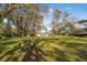Spacious backyard with mature trees and a view of the house at 4935 Sand Mountain Loop Rd, Auburndale, FL 33823