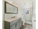 Modern bathroom with gray vanity, glass shower, and white tile at 4935 Sand Mountain Loop Rd, Auburndale, FL 33823