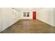 Bright living room featuring wood-look floors and a red accent door at 4935 Sand Mountain Loop Rd, Auburndale, FL 33823