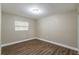 Simple bedroom with wood-look floors and a window at 5711 Bolling Dr, Orlando, FL 32808