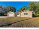 Tan single story house with a red door, attached garage, and well-maintained lawn at 5711 Bolling Dr, Orlando, FL 32808