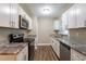 Modern kitchen featuring white cabinets, granite countertops, and stainless steel appliances at 5711 Bolling Dr, Orlando, FL 32808