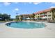 Community pool with lounge chairs and umbrellas at 6403 Parc Corniche Dr # 4309, Orlando, FL 32821