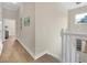 Light-filled hallway with wood-look flooring leading to bedrooms and staircase at 7544 Gathering Dr, Kissimmee, FL 34747