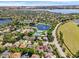 Aerial view of a lakefront community with tennis courts and lush landscaping at 10125 Canopy Tree Ct, Orlando, FL 32836