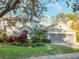 Two-story house with a three-car garage and manicured landscaping at 10125 Canopy Tree Ct, Orlando, FL 32836