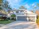 Two-story home with gray double garage and manicured lawn at 10125 Canopy Tree Ct, Orlando, FL 32836