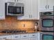 Modern kitchen details include stainless steel appliances and mosaic backsplash at 10125 Canopy Tree Ct, Orlando, FL 32836