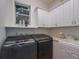 Bright laundry room, featuring washer, dryer, and cabinets at 10125 Canopy Tree Ct, Orlando, FL 32836