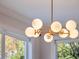 Elegant gold chandelier with white globe shades illuminates the dining area at 10125 Canopy Tree Ct, Orlando, FL 32836