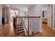 Upstairs hallway with wood floors and wrought iron railing overlooks the entryway at 10125 Canopy Tree Ct, Orlando, FL 32836