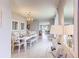 Elegant dining room with white table and chairs, chandelier, and view to the kitchen at 1593 Bull Hill Rd, Kissimmee, FL 34744