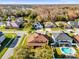 Aerial view shows manicured lawns, a pool, and mature trees surrounding homes at 15937 Birchwood Way, Orlando, FL 32828