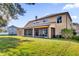 A spacious backyard featuring a covered patio, lush green lawn, and an expansive exterior view at 15937 Birchwood Way, Orlando, FL 32828