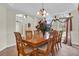 Formal dining room with a chandelier, large table, and arched windows with decorative curtains at 15937 Birchwood Way, Orlando, FL 32828