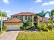 Stunning two-story home with a brick driveway and lush landscaping with well-manicured lawn at 15937 Birchwood Way, Orlando, FL 32828