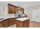 Well-lit kitchen with stainless steel refrigerator, wood cabinets, white countertops, and island at 15937 Birchwood Way, Orlando, FL 32828