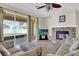 Cozy living room with a stone fireplace, tile flooring, and sliding glass doors leading to the patio at 15937 Birchwood Way, Orlando, FL 32828