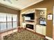 Living room with built-in shelving, fireplace, and large TV at 1701 Sparkling Water Cir, Ocoee, FL 34761