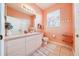 Bathroom with single sink vanity and toilet, coral walls at 2249 Wyndham Palms Way, Kissimmee, FL 34747