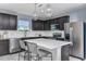 Kitchen island with quartz countertop, dark cabinets, and stainless steel appliances at 2440 Belle Haven Way, Davenport, FL 33896