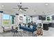 Open living room and kitchen with teal sofa, white chairs, and dark cabinets at 2440 Belle Haven Way, Davenport, FL 33896