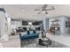 Open living room and kitchen with teal sofa, white chairs, and dark cabinets at 2440 Belle Haven Way, Davenport, FL 33896