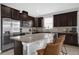 Modern kitchen with dark brown cabinets, granite countertops, and stainless steel appliances at 2662 Tahoe Ter, St Cloud, FL 34771