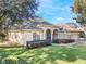 Tan house with a gray roof, lush landscaping, and a paved driveway at 268 Heatherbrooke Cir, Oviedo, FL 32765