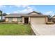 Tan house with a brown roof, stone accents, and a two-car garage at 2700 Dorado Ct, Apopka, FL 32703